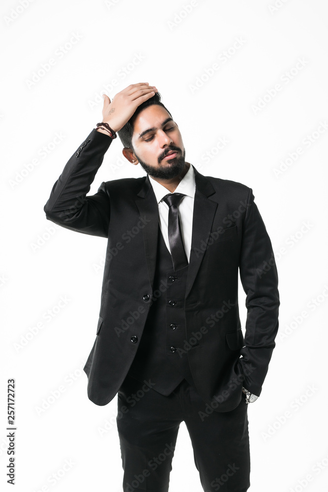 Portrait of handsome confident businessman in jacket touching his hair isolated on white