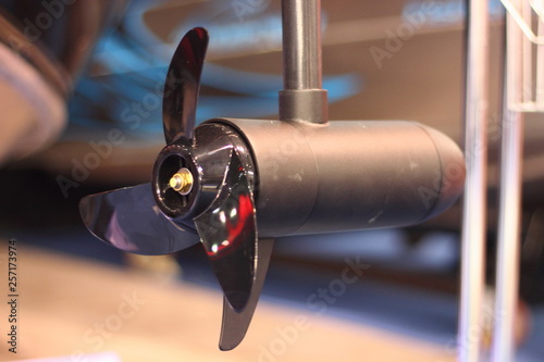 Close up black boat outboard electric motor with 3-blade propeller - rear side view