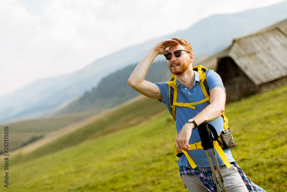 Handsome young red hair man with sunglasses hiking on the mountain Handsome young red hair man with sunglasses hiking on the mountain