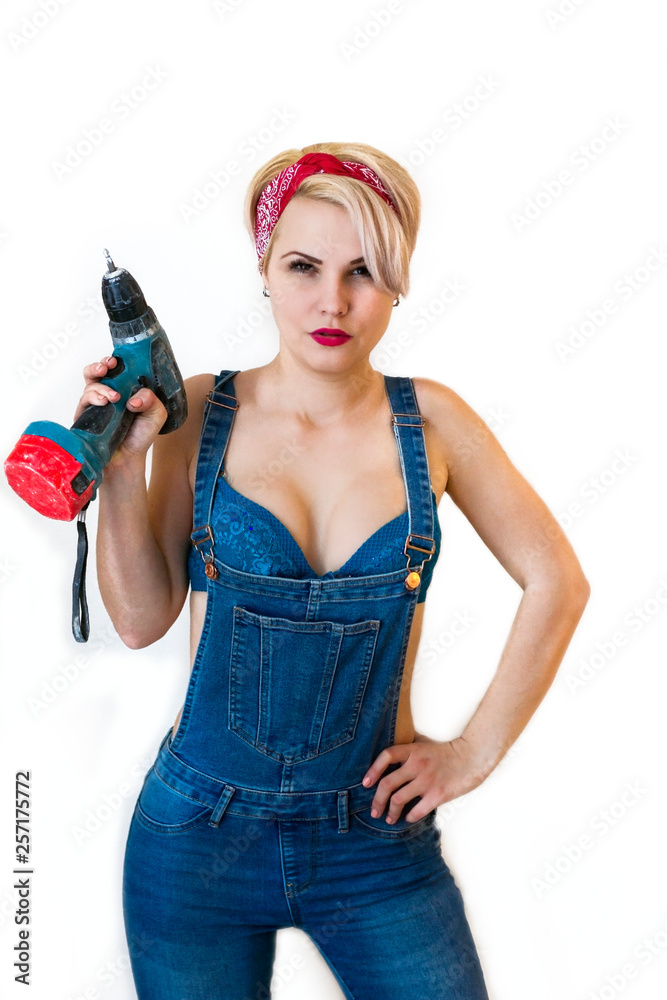 sexy blonde woman doing repairs at home. Girl builder with a screwdriver,  drill in overalls, boobs Stock Photo | Adobe Stock