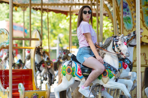teen girl rides on carousels in the Park