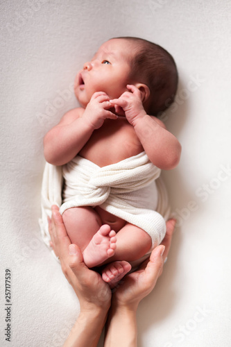 Mothercare newborn concept. Mother holding baby feet and heart