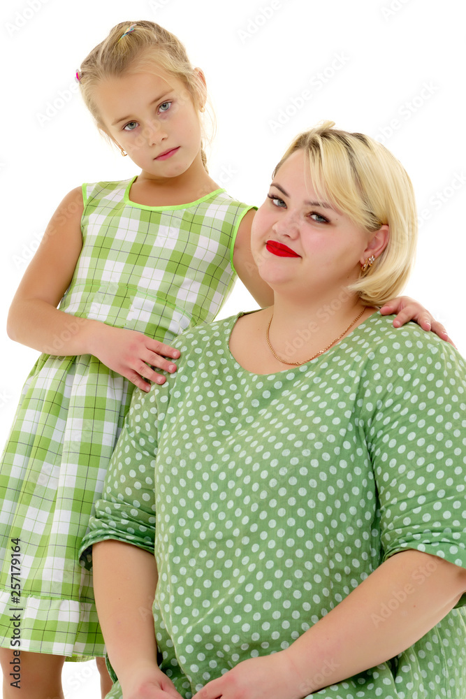 Mom and little daughter studio portrait on a white background. Mom and little daughter studio portrait on a white background.