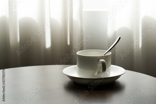 white tea cup coffee cup on the table by a sofa couch in hotel room, kettle
