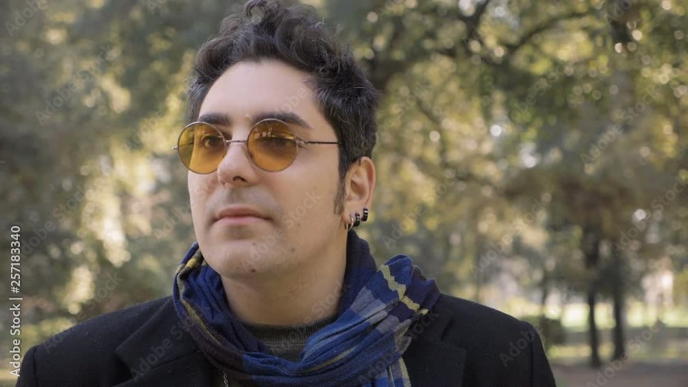 Serious confident handsome man walking alone in the park.close up-slow motion Serious confident handsome man walking alone in the park.close up-slow motion