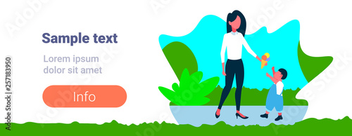 woman giving ice cream to his little son happy family walking city park mother and child having fun landscape background full length flat horizontal copy space