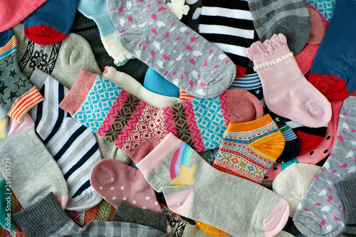 A pile of socks of different colors. Many socks of different colors and sizes create a background. View from above. Knitted clothing in the form of socks.