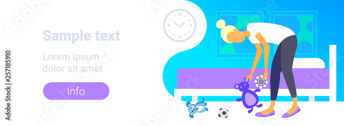 housewife picking up her children toys mother collecting kids plaything housework concept modern apartment bedroom interior female character full length horizontal copy space