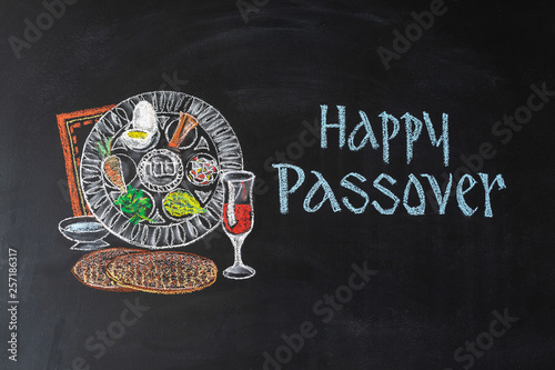 Passover plate and traditional food for Passover (Pesach) on chalkboard. Passover dinner, seder pesach.