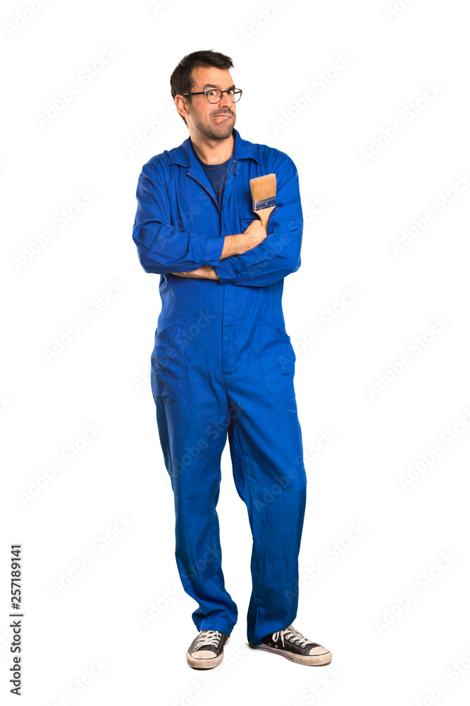 A full-length shot of a Painter man with confuse face expression while bites lip on isolated white background A full-length shot of a Painter man with confuse face expression while bites lip on isolated white background