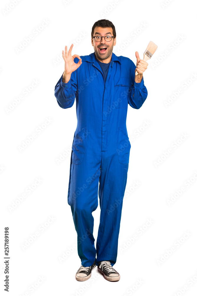 A full-length shot of a Painter man showing ok sign with and giving a thumb up gesture on isolated white background A full-length shot of a Painter man showing ok sign with and giving a thumb up gesture on isolated white background