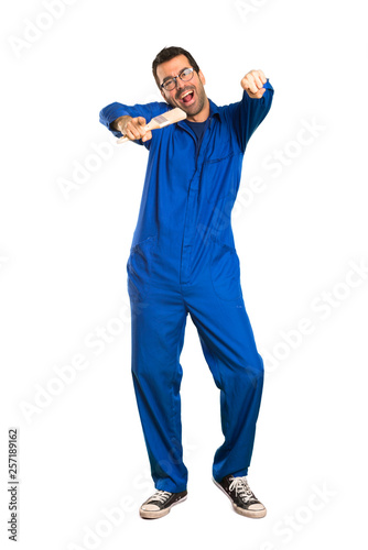 A full-length shot of a Painter man points finger at you while smiling on isolated white background