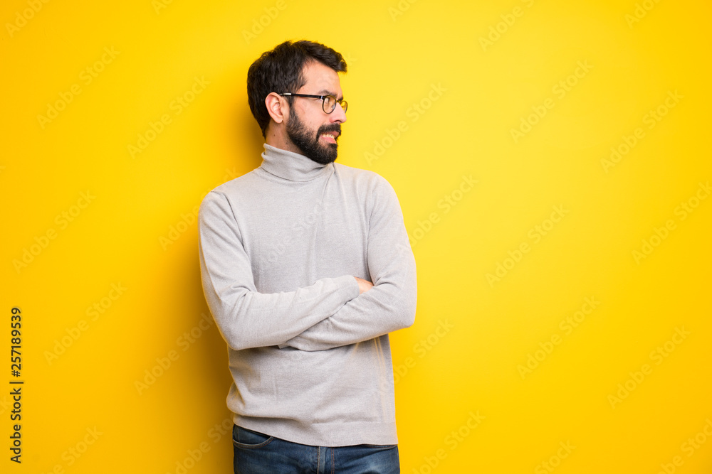 Man with beard and turtleneck is a little bit nervous and scared pressing the teeth