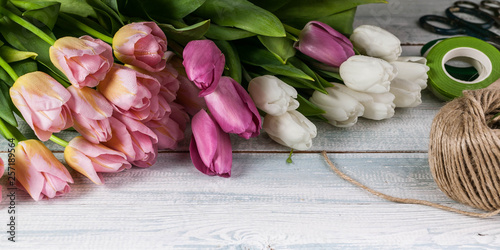Easter horizontal banner. Multicolored tulips on a horizontal wooden background.