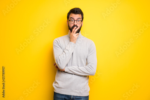 Man with beard and turtleneck surprised and shocked while looking right