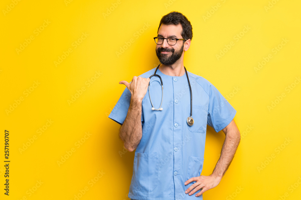 Surgeon doctor man pointing to the side to present a product Surgeon doctor man pointing to the side to present a product
