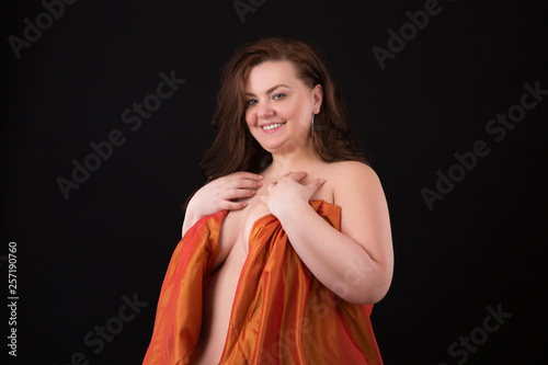 Portrait of a plus size beautiful young woman wrapped in a blanket. Perfect makeup and hair. XXL Model.