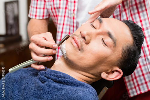 Barber shaving with straight razor