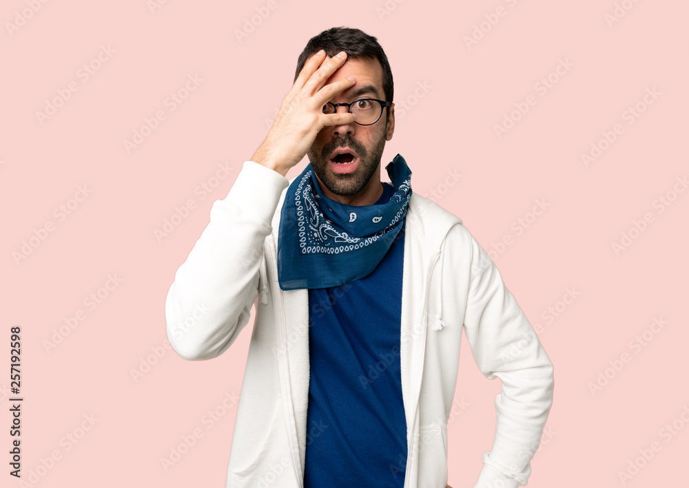 Handsome man with glasses with surprise and shocked facial expression on isolated pink background Handsome man with glasses with surprise and shocked facial expression on isolated pink background