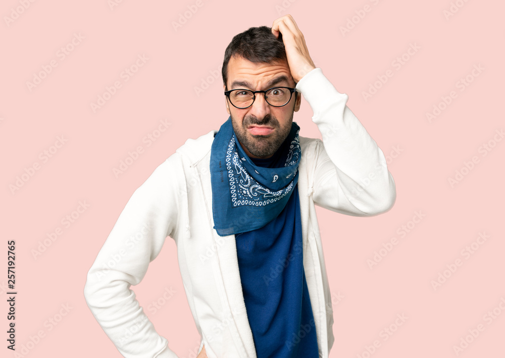 Handsome man with glasses with an expression of frustration and not understanding on isolated pink background Handsome man with glasses with an expression of frustration and not understanding on isolated pink background