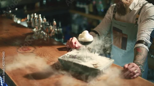 Barman is making cocktail at night club. Unique man.