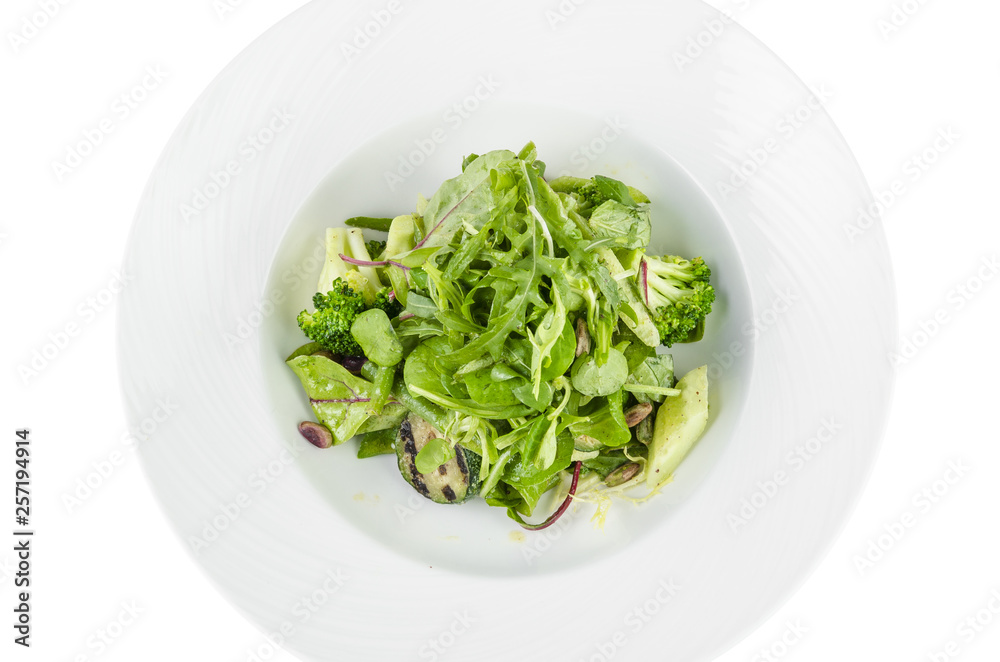 Salad of green vegetables with broccoli, zucchini and walnut dressing on a plate on a white background, top view isolated Salad of green vegetables with broccoli, zucchini and walnut dressing on a plate on a white background, top view isolated