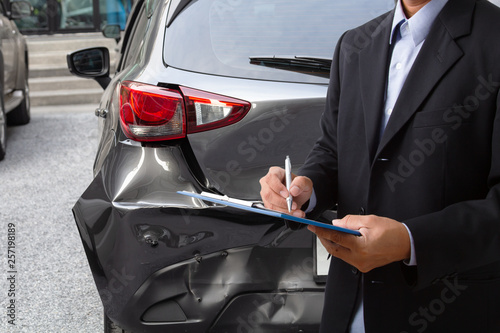 Quadro em tela nsurance officer writing on clipboard while insurance agent examining car after accident
