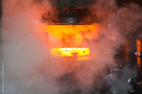 Steel press rolling industrial workshop. Hot iron stamping of train and wagon wheels. Industrial details of metallurgic factory or plant.