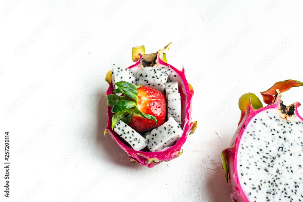 pink and white dragon fruit with a dried pulp and strawberry in the middle