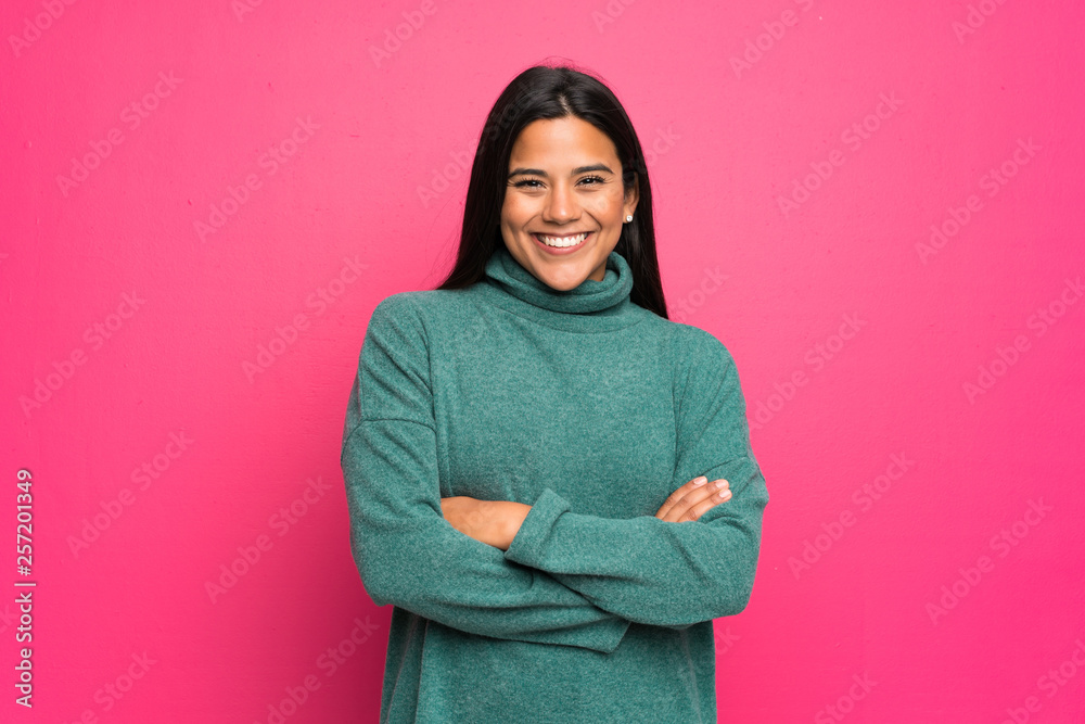 Young Colombian girl with green sweater keeping the arms crossed in frontal position Young Colombian girl with green sweater keeping the arms crossed in frontal position