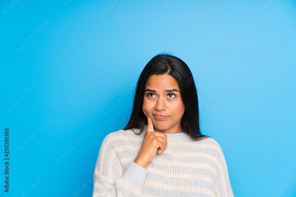 Young Colombian girl with sweater thinking an idea Young Colombian girl with sweater thinking an idea