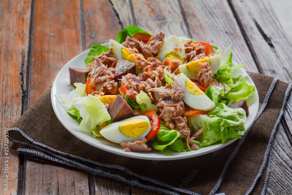 tuna salad with boiled egg, tomato slice, sweet potato and lettuce on white dish. Healthy food for loose weight, high fiber and low fat.