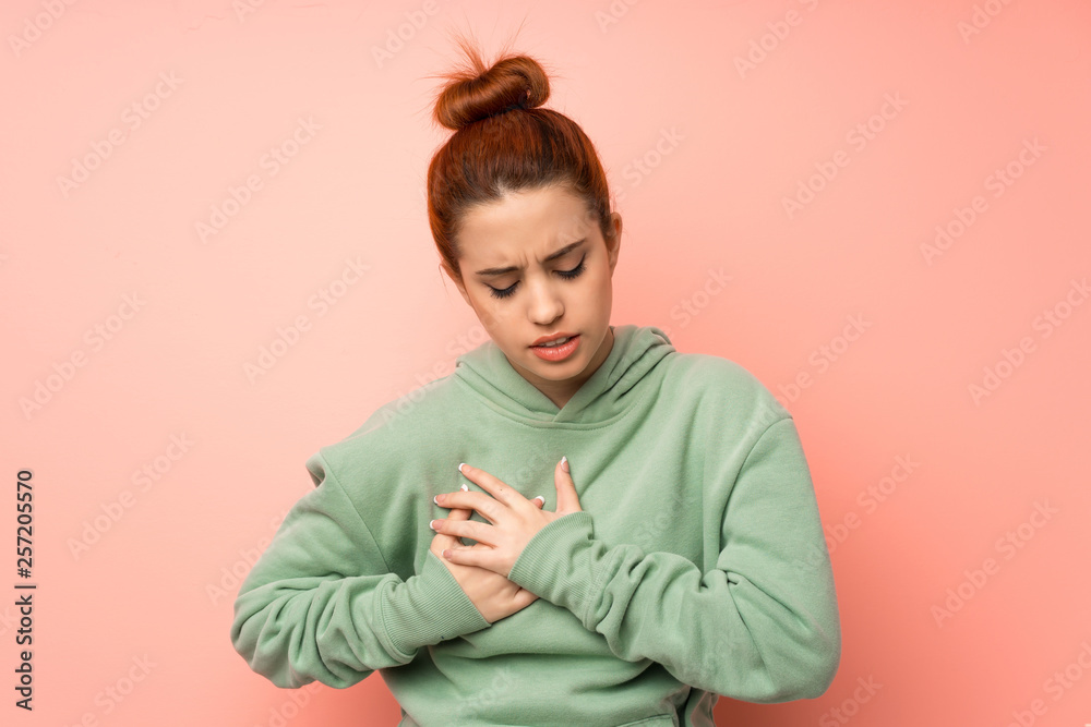 Young redhead woman with sweatshirt having a pain in the heart Young redhead woman with sweatshirt having a pain in the heart