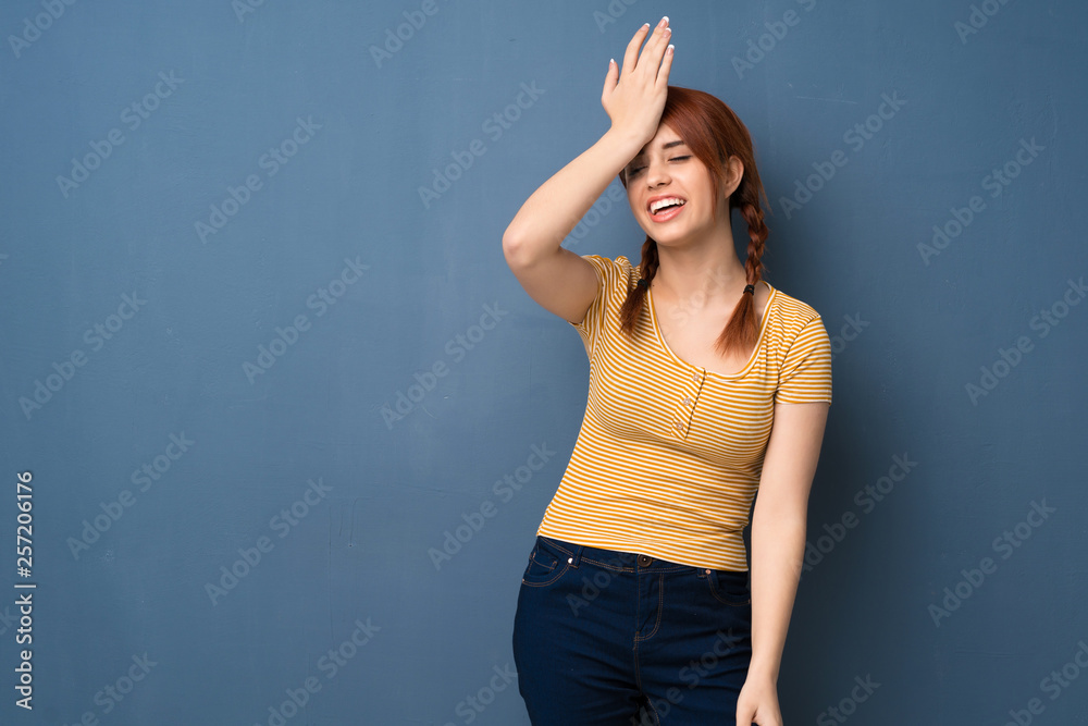 Young redhead woman over blue background has just realized something and has intending the solution Young redhead woman over blue background has just realized something and has intending the solution