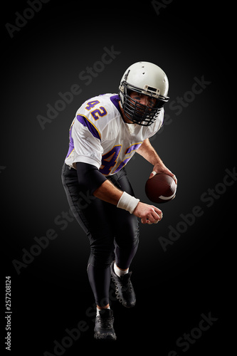 American football sportsman player on black background. Sport concept.