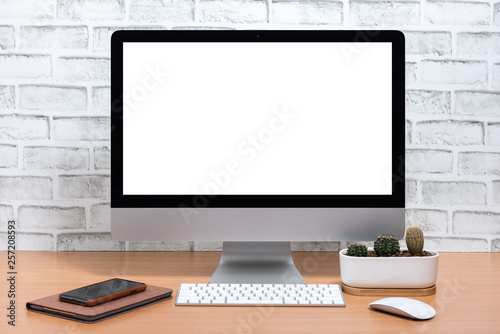 Blank screen of All in one Computer with tablet, smart phone and cactus pot on wooden table, White brick wall background