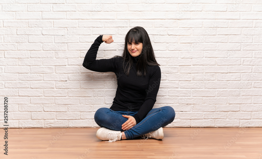 Woman sitting on the floor Doing strong gesture Woman sitting on the floor Doing strong gesture