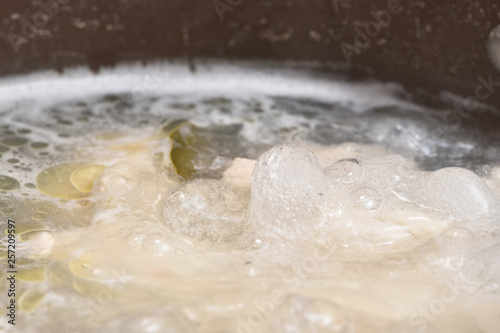 Transparent and fatty broth boils and boils in a saucepan. Close-up