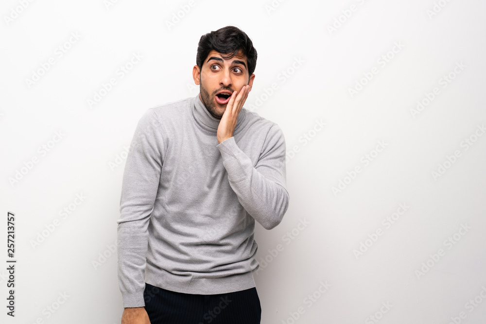 Young man over isolated white wall with surprise and shocked facial expression Young man over isolated white wall with surprise and shocked facial expression
