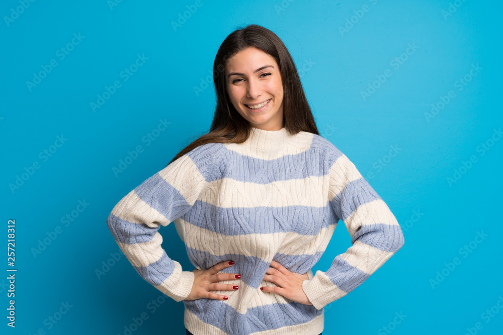 Young woman over blue wall happy and smiling Young woman over blue wall happy and smiling