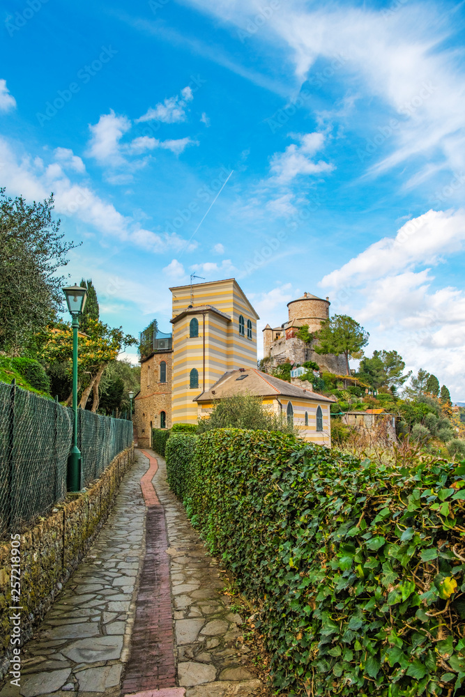 Narrow road of italian town Portofino with the view to the castle Brown, Liguria region, Italy