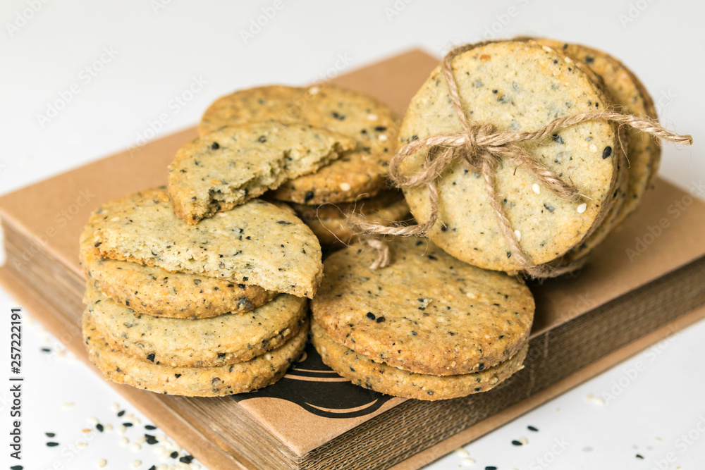 Sesame cookies pile with rustic twine isolated on white background