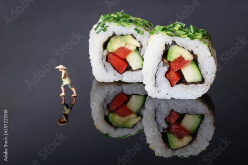 Sushi Rollen auf schwarzem acrylglas und Reisbauer photo