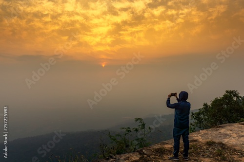 Tourist taking picture of sunrise sky nature background