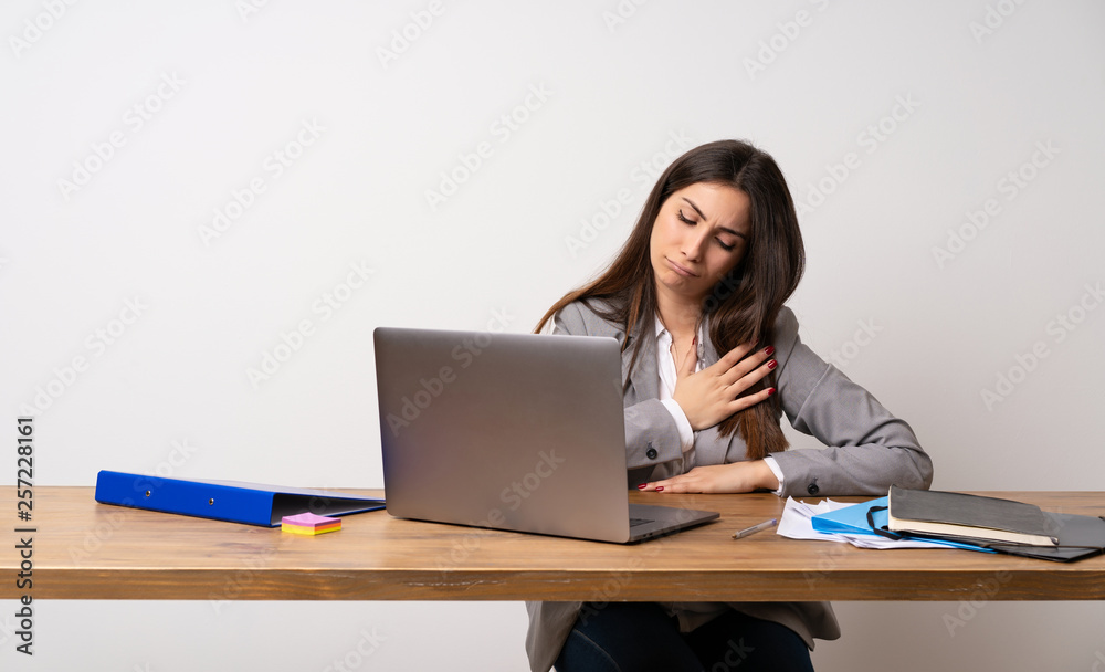 Business woman in a office having a pain in the heart Business woman in a office having a pain in the heart