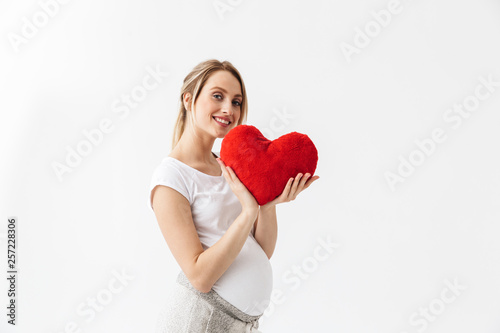 Beautiful young pregnant woman standing isolated