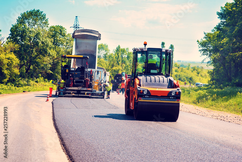 Obraz na płótnie industrial landscape with rollers that rolls a new asphalt in the roadway. Repair, complicated transport movement. w salonie