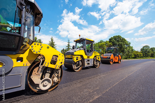 Obraz na płótnie industrial landscape with rollers that rolls a new asphalt in the roadway. Repair, complicated transport movement. w salonie
