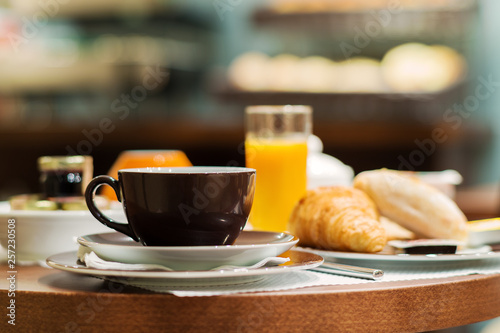 Cup of coffee with croissant and bread on wooden table