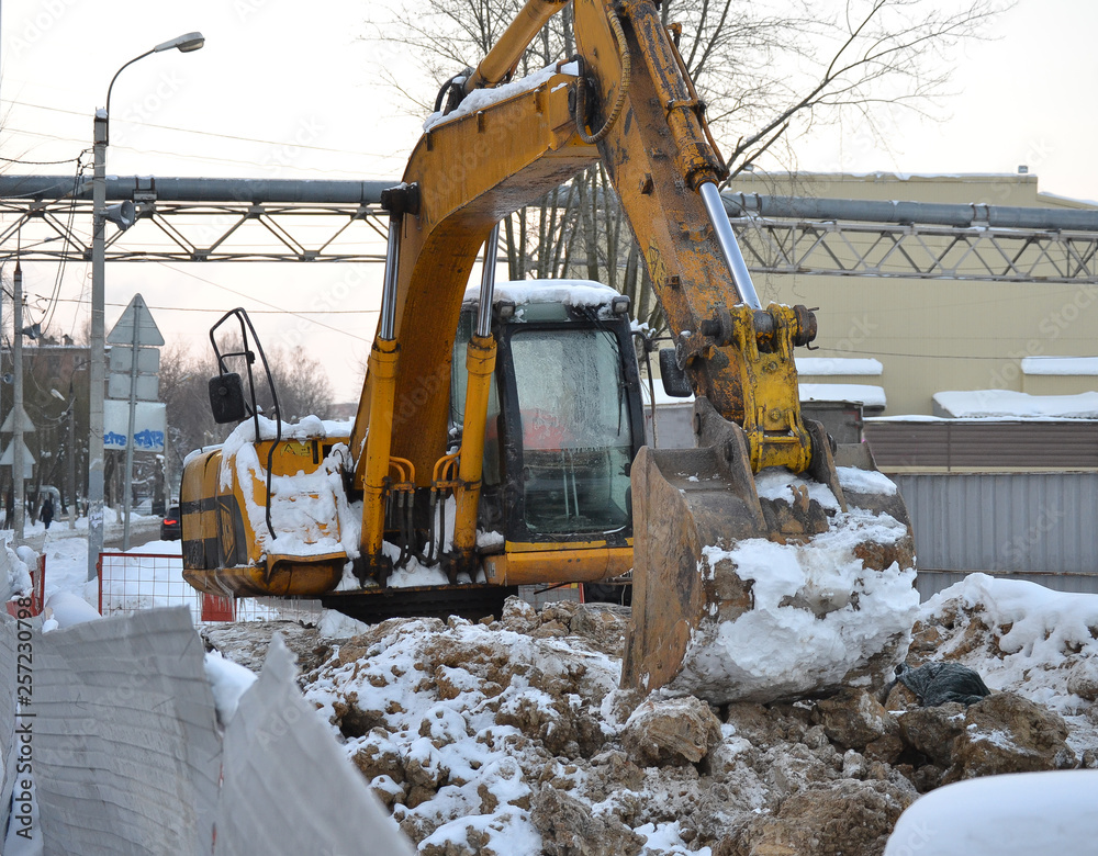 Excavator close up. Repair work in the winter on the street. Russia. Excavator close up. Repair work in the winter on the street. Russia.